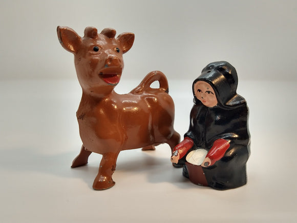 Painted salt and pepper shakers shaped like a cow and a milkmaid