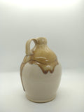 Gold and white glazed ceramic vessel with a handle