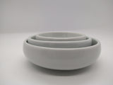 Side view of three ceramic Chinese bowls fitting into each other