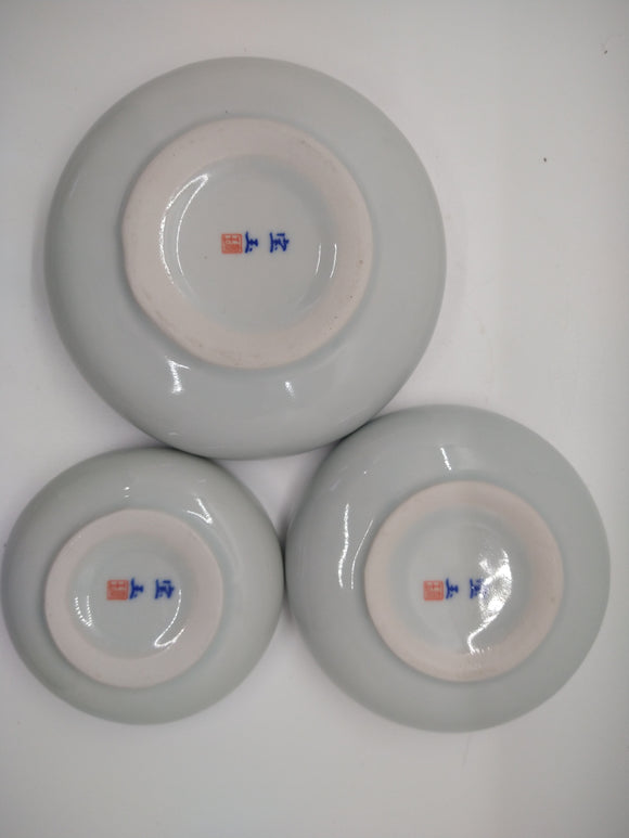 The undersides of a trio of Chinese ceramic bowls, all of different sizes