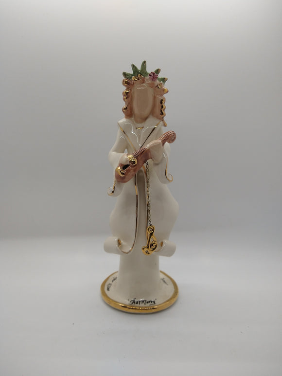 Ceramic sculpture of a woman playing an instrument that serves as a candle holder